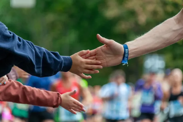 Hands meeting in high five during a marathon. Photo.